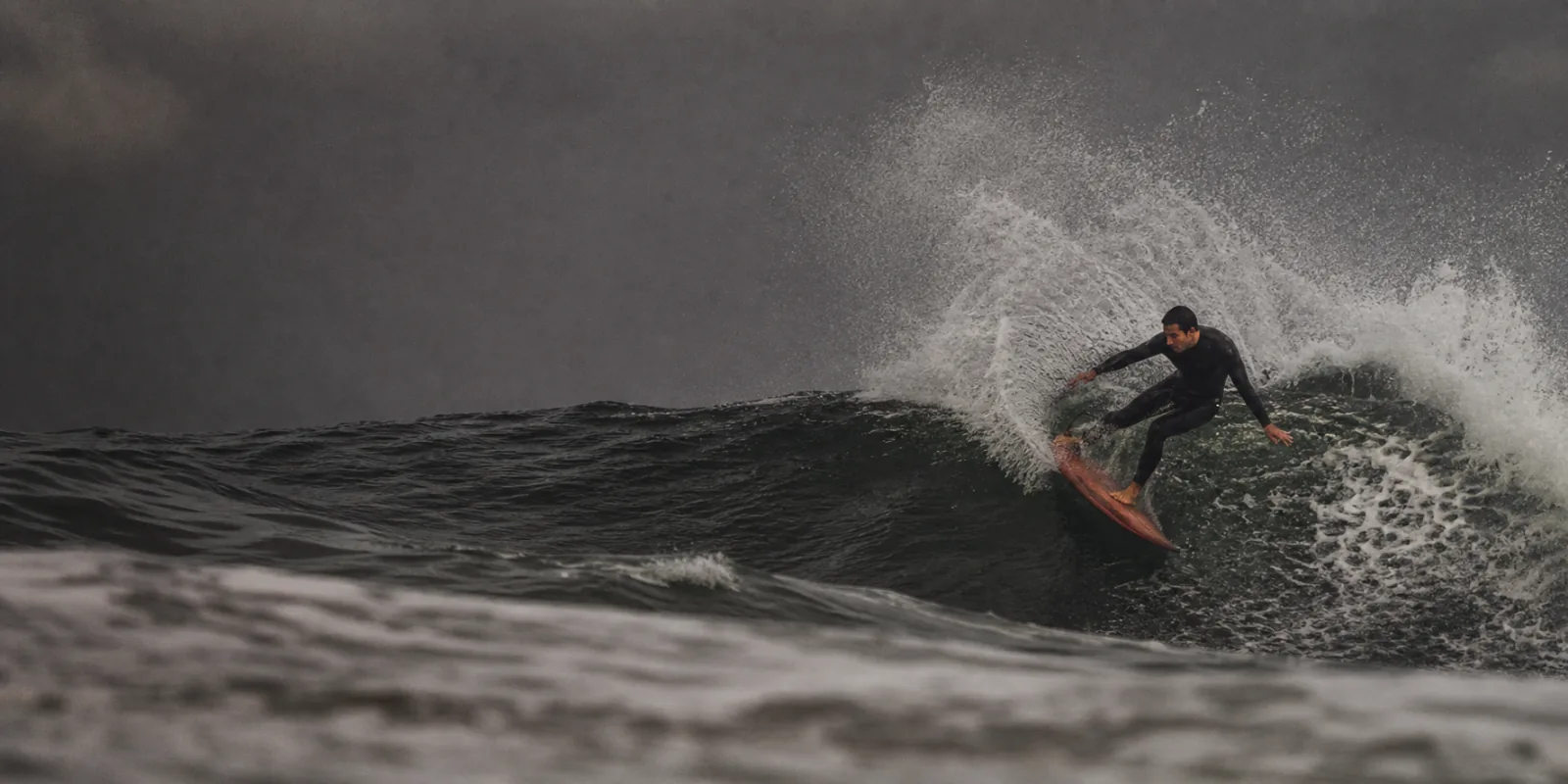 Surfista a desenhar uma curva numa onda em Carcavelos