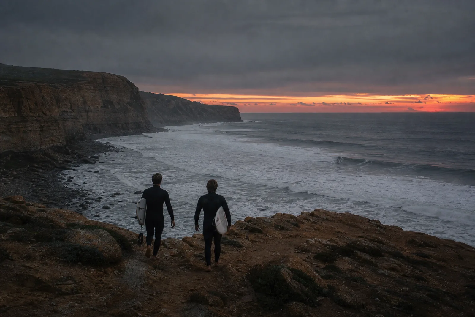 Surfistas a caminhar para o mar ao amanhecer na Ericeira